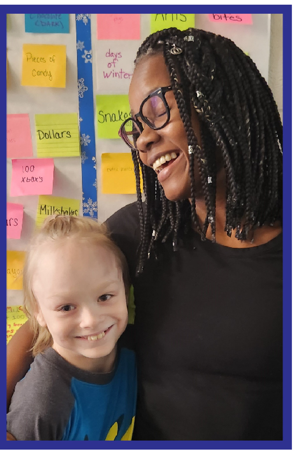A child and his teacher smiling together